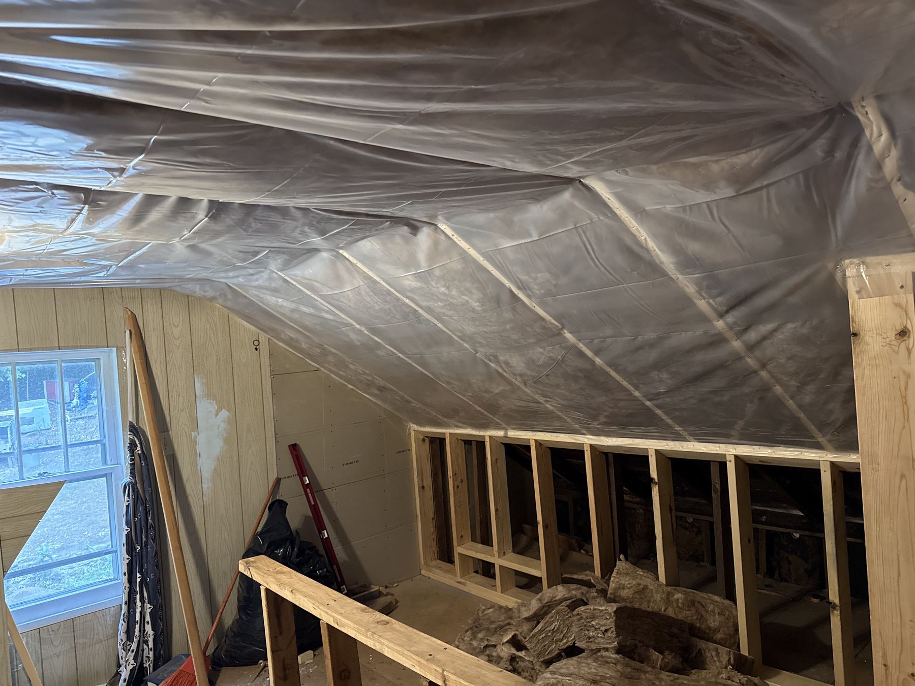 Vapor barrier installation along a vaulted ceiling with window
